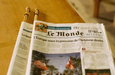 Le Monde newspaper placed on a wooden table, depicting European news.